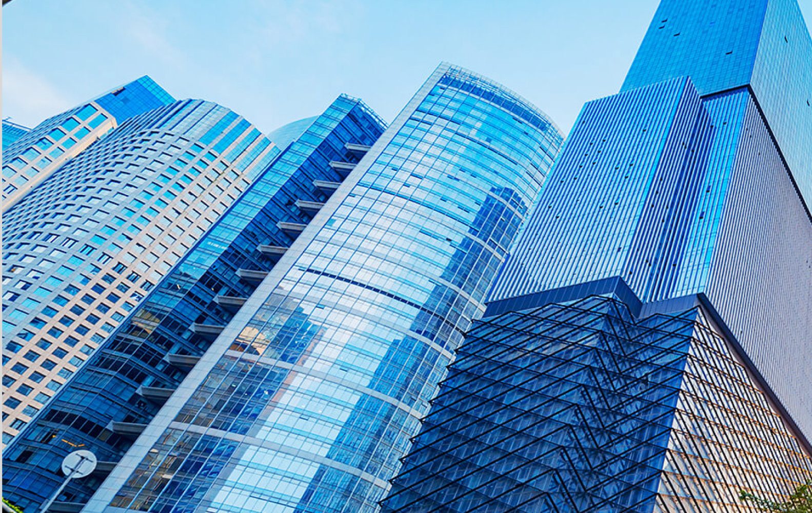 Grattacieli moderni in vetro e acciaio si ergono contro un cielo blu luminoso.